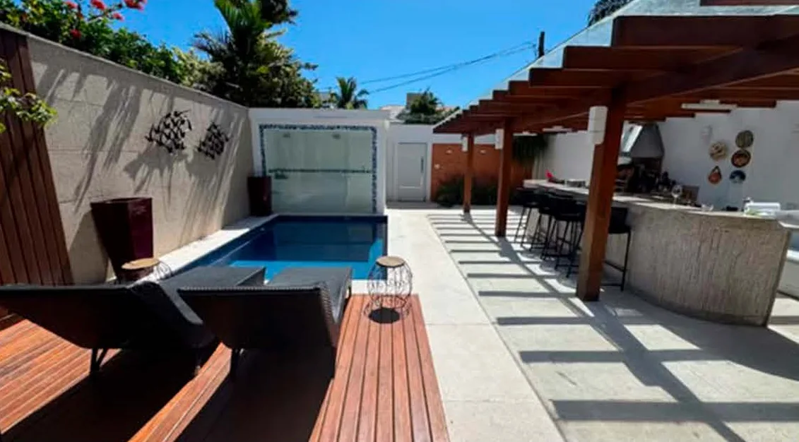 Piscina com deck de madeira e bar